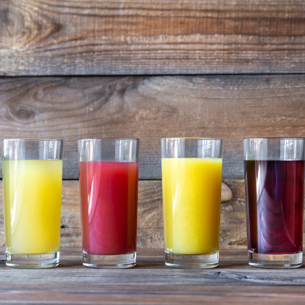 Assortment of fruit juices on the wooden background